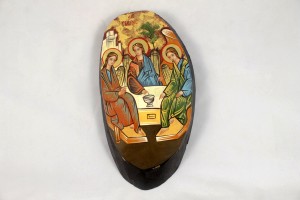 Icona dipinta a mano raffigurante Trinità Rublev su sezione di tronco.